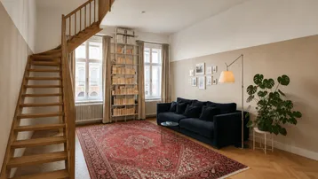 Helles Wohnzimmer mit Holztreppe, Fischgrätparkett und einem großen roten Teppich.