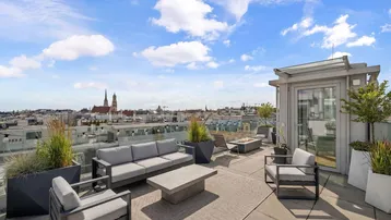 Geräumige Dachterrasse mit modernen Lounge-Möbeln und weitem Blick über die Stadt.