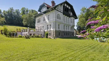 Elegante Villa mit weitläufigem Garten und gepflegter Rasenfläche in sonniger Lage.