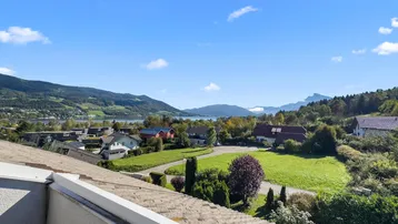 Panoramablick über die umliegende Landschaft mit See und Bergen unter blauem Himmel.