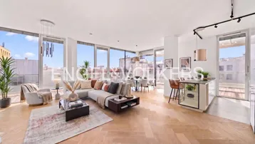 Heller, offener Wohn- und Essbereich mit moderner Einrichtung, Parkettboden und Zugang zur Terrasse.