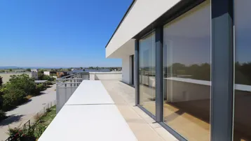 Große Dachterrasse mit weitem Blick über die Umgebung und den See, ideal für entspannte Stunden im Freien.
