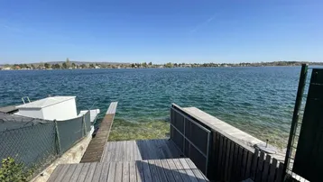 Holzsteg und Terrasse mit direktem Zugang zum See und weitem Seeblick.