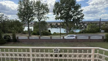 Panoramablick vom Balkon auf den See und die umliegende Berglandschaft.