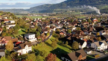 Weitläufige Luftaufnahme des Hauses in ländlicher Umgebung mit Bergen im Hintergrund.