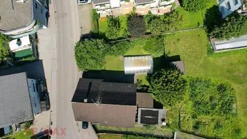 Luftaufnahme des Grundstücks mit Wohnhaus, Garten, Gewächshaus und Poolbereich.
