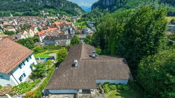 Dachansicht des Hauses mit Blick auf die umliegende Stadt und die beeindruckende Berglandschaft.