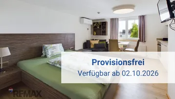 Helles Schlafzimmer mit integriertem Wohnbereich, Küchenzeile und Klimaanlage.