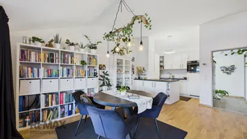 Offener Wohn-Essbereich mit integrierter Küche und Bücherregal.