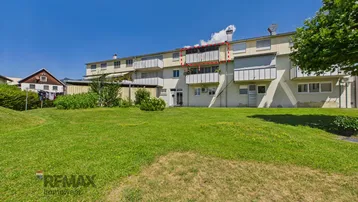 Mehrfamilienhaus mit großem Garten und Balkonen in sonniger Lage.