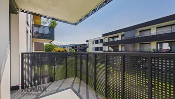 Geräumiger Balkon mit modernem Gittergeländer und Blick auf die umliegenden Gebäude.