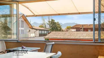 Offener Wintergarten mit ausfahrbarer Markise und Panoramablick auf die Berge.