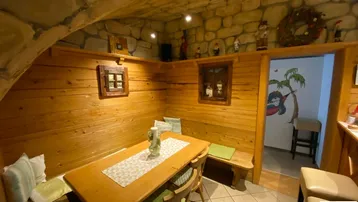 Rustikaler Essbereich mit Holzvertäfelung, Steindecke und traditioneller Dekoration.