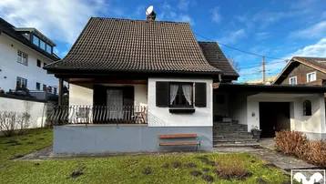 Charmantes Einfamilienhaus mit Satteldach, kleinem Vorgarten und überdachtem Eingangsbereich.