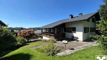 Großzügiger Gartenbereich mit Rasenfläche und Blick auf das charmante Einfamilienhaus in sonniger Lage.