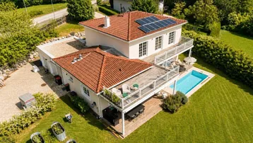 Luftaufnahme des Hauses mit Pool, Terrasse und Photovoltaikanlage auf dem Dach.
