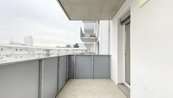 Geräumiger Balkon mit moderner Brüstung und Blick auf die umliegende Wohnbebauung.