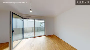 Helles Wohnzimmer mit Holzboden und bodentiefen Fenstern, die Zugang zu einer Terrasse bieten.