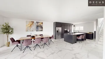 Moderner offener Wohn- und Essbereich mit integrierter Küche und eleganten Fliesenboden.