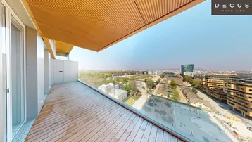 Geräumiger Balkon mit Holzbelag und Glasgeländer bietet einen weiten Blick über die Stadt.