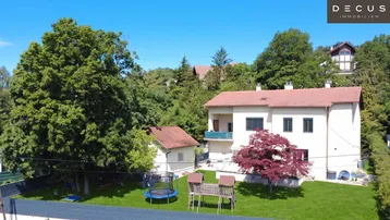 Luftaufnahme des Hauses mit großem Garten, Spielplatz und Trampolin in grüner Umgebung.