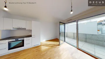 Helle Wohnküche mit modernen weißen Schränken, Holzboden und Zugang zu einem geräumigen Balkon.