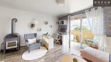 Helles Wohnzimmer mit Kaminofen, Arbeitsbereich und direktem Zugang zum Balkon.