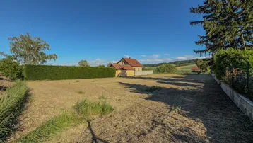 Weitläufiges Grundstück mit Blick auf die umliegende Landschaft und angrenzende Häuser.