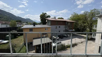 Blick vom Balkon auf die umliegende Bebauung und die majestätischen Berge im Hintergrund.