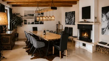 Geräumiger Essbereich mit großem Holztisch, Kamin und sichtbaren Deckenbalken in rustikalem Stil.