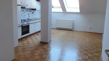 Helle Dachgeschosswohnung mit offener Küche, Parkettboden und Dachfenstern für viel Tageslicht.