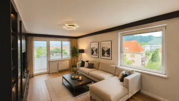 Helles Wohnzimmer mit modernem Sofa, Holzboden und Zugang zum Balkon mit Blick ins Grüne.