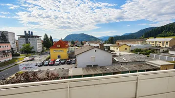 Weitläufiger Ausblick vom Balkon auf die Stadt und die umliegende Berglandschaft.