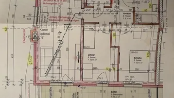 Detaillierter Grundriss einer Wohnung mit Balkon, Wohnküche und zwei Schlafzimmern.