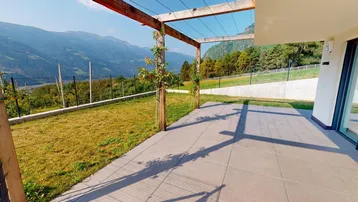 Große geflieste Terrasse mit Holzpergola, Rasenfläche und beeindruckendem Bergblick in die Ferne.