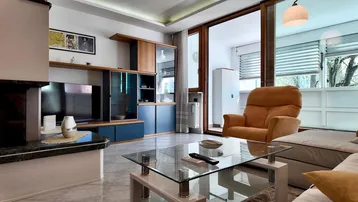 Gemütliches Wohnzimmer mit Kamin, TV-Möbeln und Zugang zu einem Balkon.