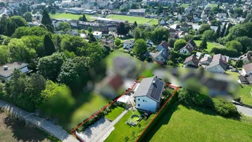 Luftaufnahme eines Einfamilienhauses mit Garten, Solaranlage und Blick auf die umliegende Landschaft und einen Fluss.