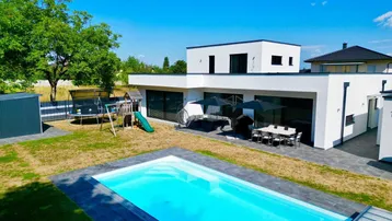 Moderner Neubau mit großem Garten, Swimmingpool, Spielplatz und Terrasse für entspannte Stunden im Freien.
