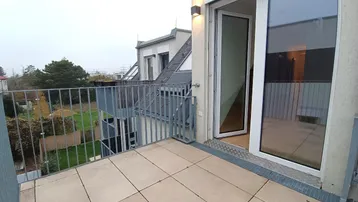 Geräumiger Balkon mit Fliesenboden und Blick auf die Umgebung, ideal für entspannte Stunden im Freien.