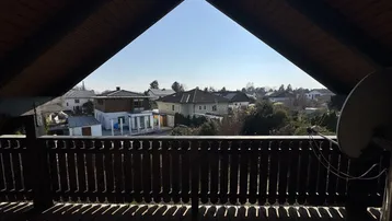 Panoramablick vom Balkon über die umliegende Wohnsiedlung unter einem strahlend blauen Himmel.
