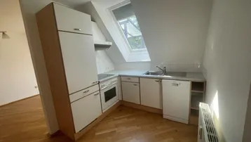 Funktionale Küchenzeile mit Dachfenster, Herd und Spüle in einem offenen Wohnkonzept.