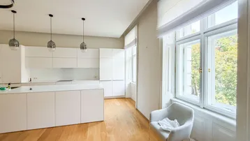 Helle, moderne Küche mit weißer Kücheninsel, Holzboden und großen Fenstern.