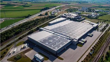 Luftaufnahme eines großen Logistikzentrums mit Solaranlagen auf dem Dach und guter Verkehrsanbindung.
