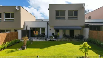 Moderne Reihenhäuser mit gepflegten Gärten und sonnigen Terrassen für entspannte Stunden im Freien.