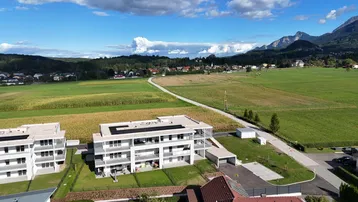 Luftaufnahme der modernen Wohngebäude in ländlicher Umgebung mit Bergblick und Feldern.
