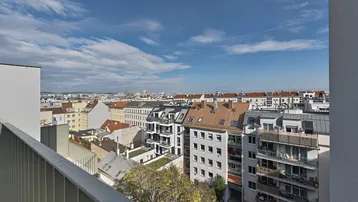 Weitläufiger Blick über die Stadt Wien von einer Dachterrasse mit modernem Metallgeländer.