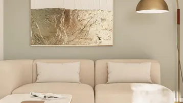 Helles Wohnzimmer mit modernem Sofa, abstraktem Kunstwerk und eleganter Stehlampe.
