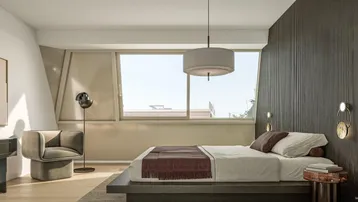 Helles Schlafzimmer mit modernem Design, großem Fenster und gemütlicher Leseecke unter der Dachschräge.
