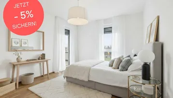 Helles Schlafzimmer mit Holzboden, großem Bett und Zugang zu einem französischen Balkon.