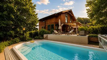 Charmantes Holzhaus mit privatem Pool und sonniger Terrasse, umgeben von grüner Natur.